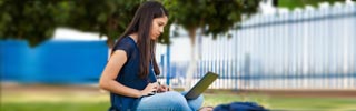 Image of a student working on a laptop outside