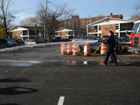 Arlington Fire Department uses a firehose to demonstrate water infiltration through the porous pavement.