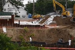 workers in HAZMAT suits cleaning an excavation site