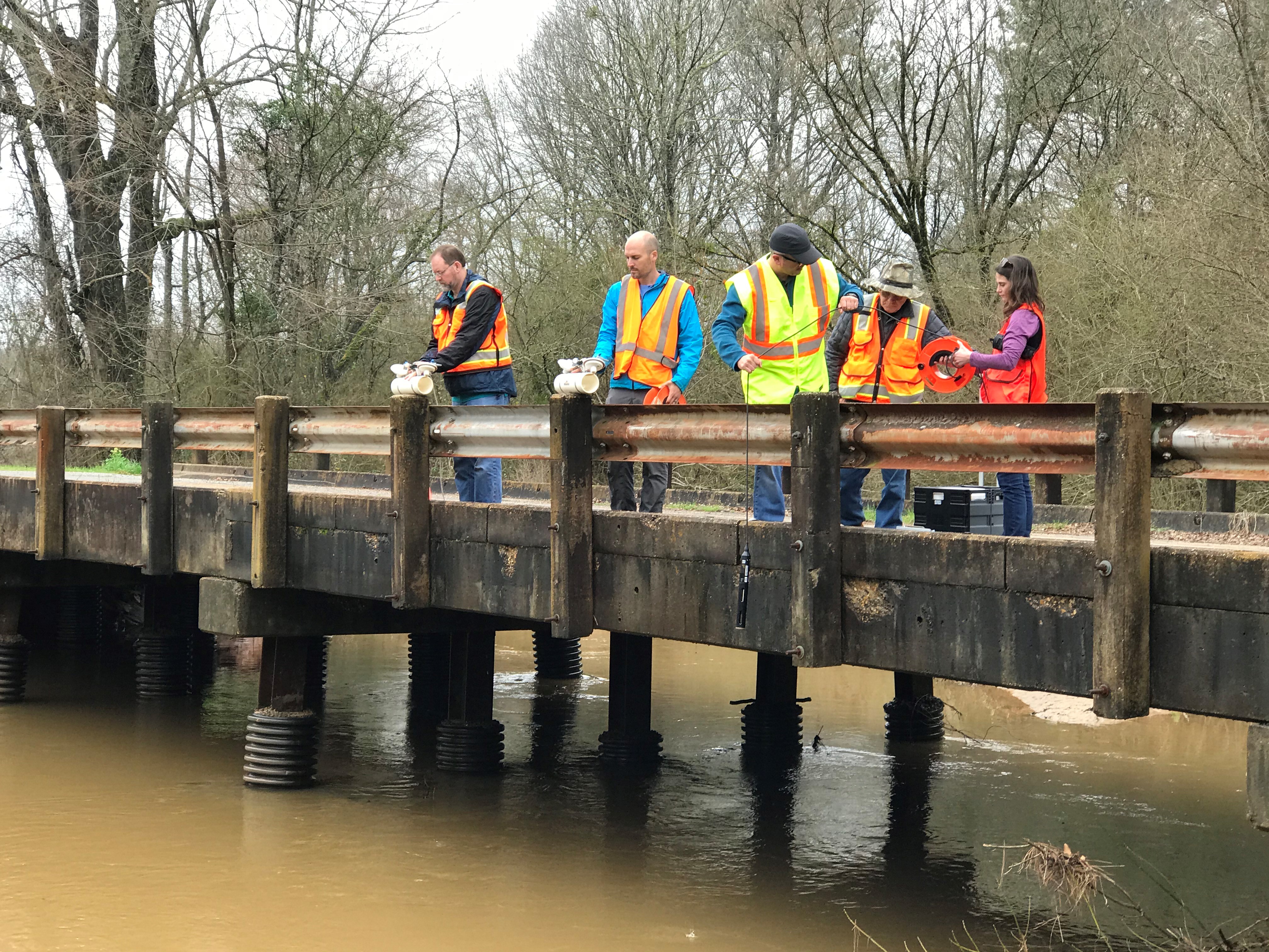 five people standing on a bridge