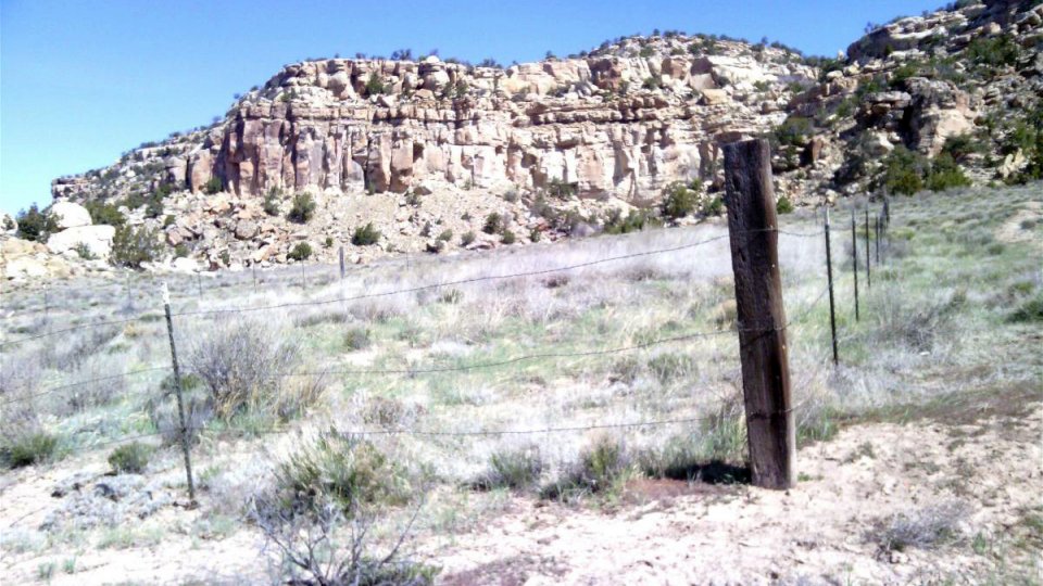 Desert landscape with barbed wire fencing visible