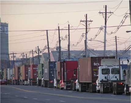 Photo of drayage trucks queued on city street