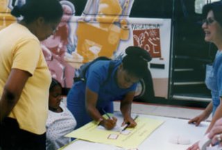 People signing papers in front of a bus