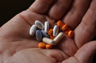 A hand holding various pharmaceuticals