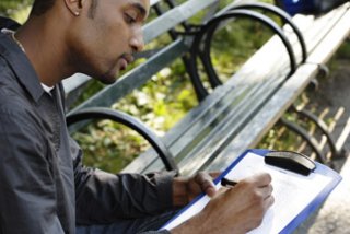 A photograph of a man taking notes.