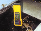 Measuring moisture levels of a subfloor.