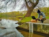 Will Helt of the Nature Conservancy programs water level monitoring equipment to be deployed at the outflow to Elm Lake in Roger Williams Park.