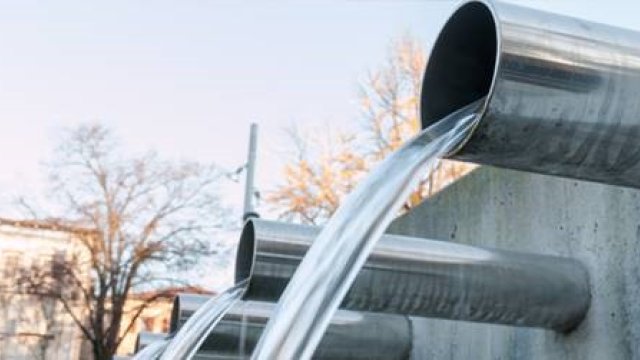 Clear water pours from industrial pipes