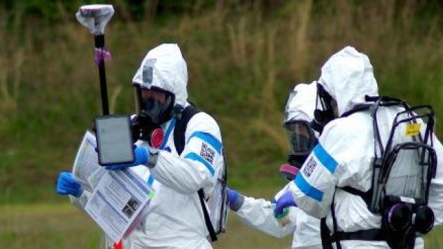 Three responders outdoors in hazmat protective equipment