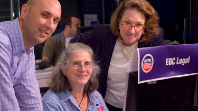 One male and two female EPA employees in front of a computer monitor.