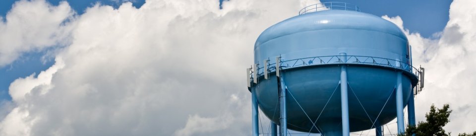 Blue water tower in front of blue cloudy sky