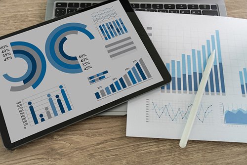 This is a photo of some generic charts and graphs on top of a laptop keyboard.