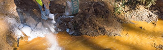 Worker adding lime to a settling pond to assist in the pH adjustment of the water prior to discharge to Cement Creek on Aug 14, 2015. (Credit: Eric Vance/EPA)