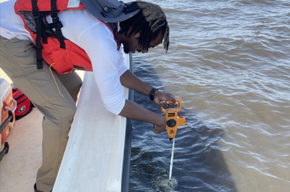 Crew Member Lowering Secchi Disk into Water