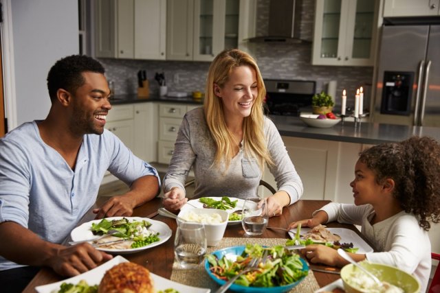 This is a picture of a woman, a man and a child eating a meal together.