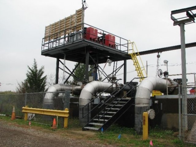 Photograph showing an elevated platform with electrical components mounted high above expected floodwater levels. A stairway leads to the platform.