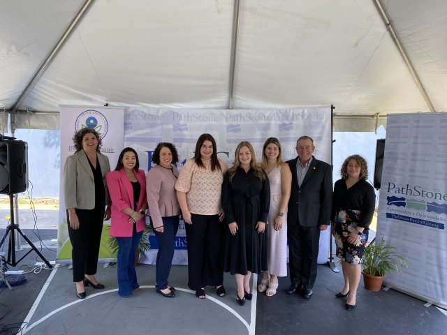 Figure 1 EPA and Puerto Rico government officials pose standing with representatives from PathStone under a white tent.