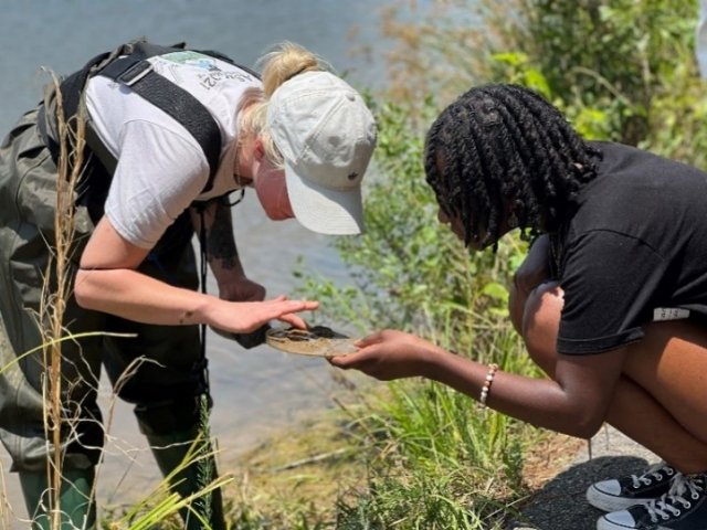 AJ Blackburn shows SSI student a microinvertebrate sample.