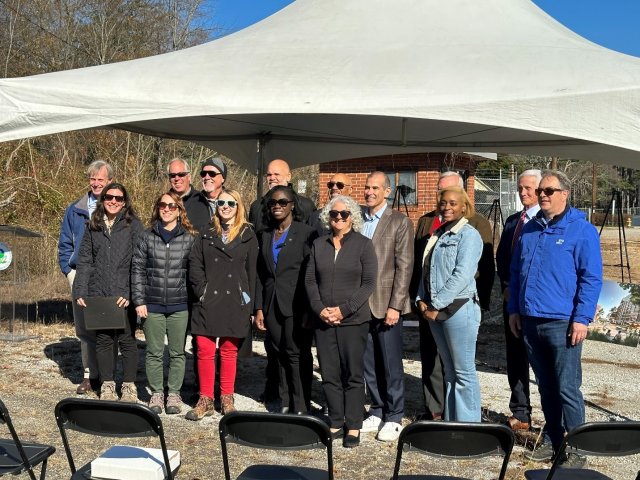 Award recipients posing for a picture under a tent.