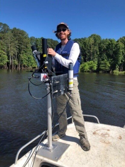 EPA researcher Wilson Salls preparing instruments on a boat for a satellite overpass.