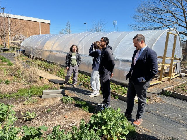 People are seen standing in front of a garden.