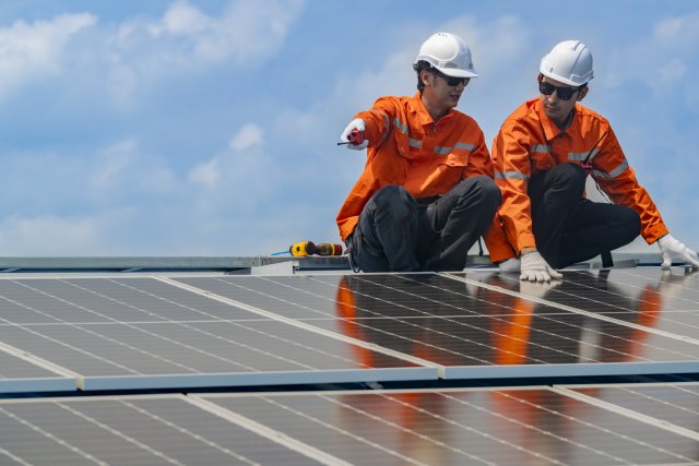 Worker Technicians assessing solar panels for reuse.