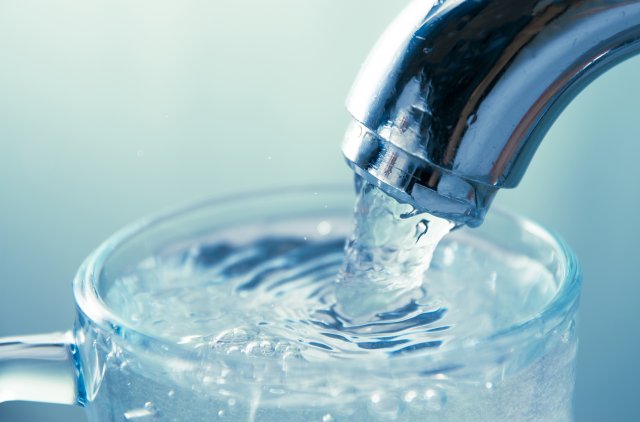 Water glass filling with water from tap