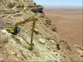 Excavator suspended by cables hauling material out of the Skyline mine area