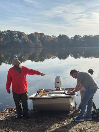 Two scientists in front of a boat used for sampling.